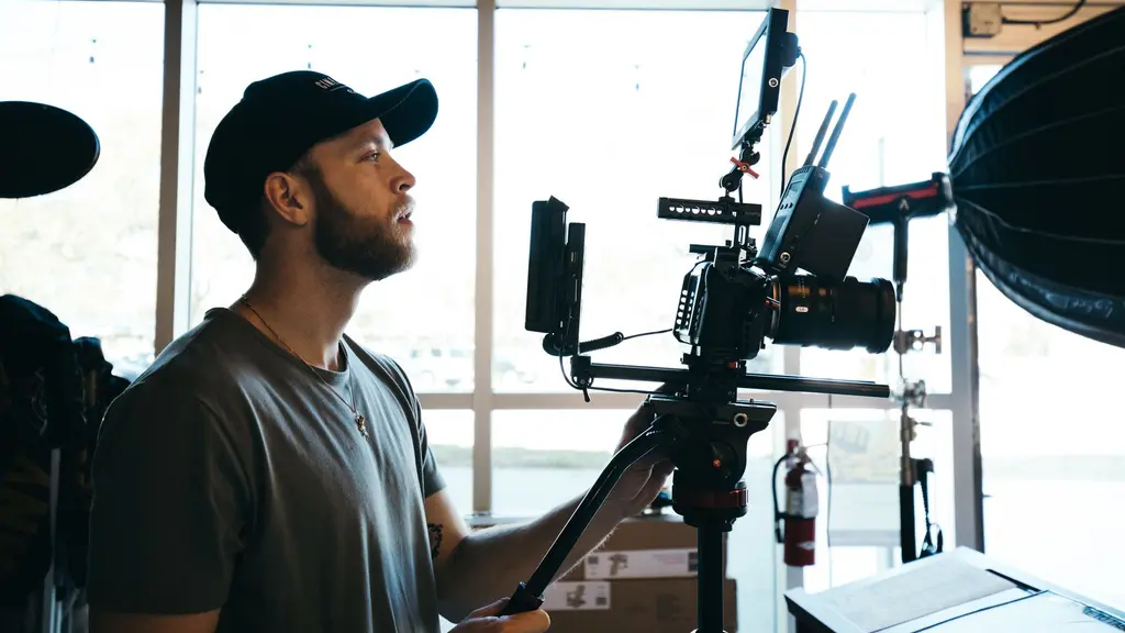 a camera operator on a rooftop at dusk